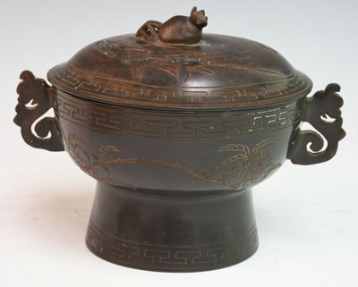 a large metal bowl with a lid on a table