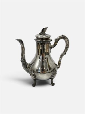 une théière ancienne en argent surmontée d'un oiseau