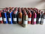 de nombreuses bouteilles contenant du fil de différentes couleurs, posées sur une table
