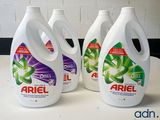 four bottles of ariel liquid sitting on top of a counter