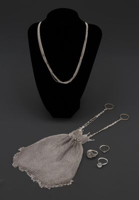 un collier, une bague et des boucles d'oreilles posés sur un présentoir pour mannequin