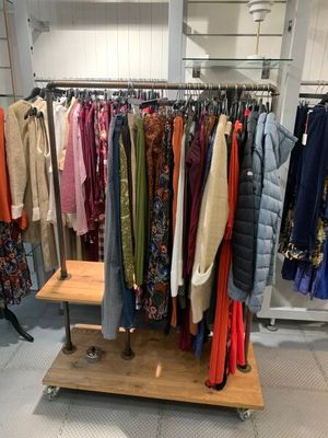 un portemanteau dans un magasin de vêtements, sur lequel sont suspendus des vêtements