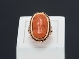 a gold ring with an orange stone in the center