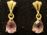 two pairs of gold and pink stone earrings on a black surface