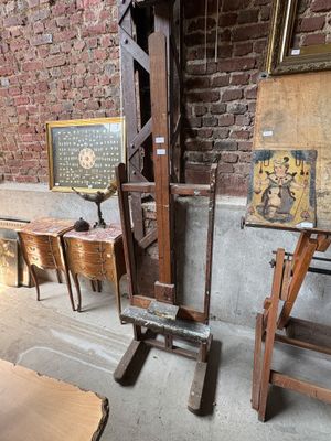a wooden easel with a painting on it in front of a brick wall