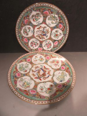 two plates with floral designs on them are sitting on a table
