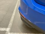 a blue car that is parked in a parking lot