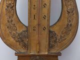 a clock that has a thermometer on top of it