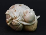 a small figurine of a sleeping baby on a black surface