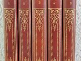 cinq livres rouges sont alignés en rang sur une table