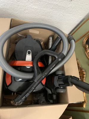 une boîte contenant un aspirateur et un tuyau