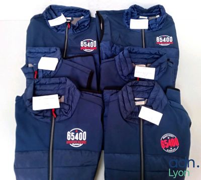 four blue jackets are lined up in a row with tags on them