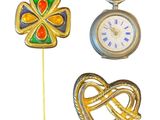 trois bijoux représentant respectivement une horloge, un cœur et une croix