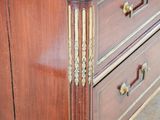 a wooden dresser with a marble top and gold trim