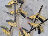 Plusieurs outils sont disposés au sol, sur une surface en béton.