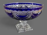 a blue glass bowl sitting on top of a clear base