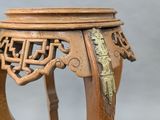 a small wooden table with a gold decoration on top of it