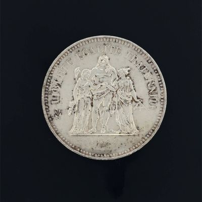 gros plan d'une pièce de monnaie en argent sur une surface noire
