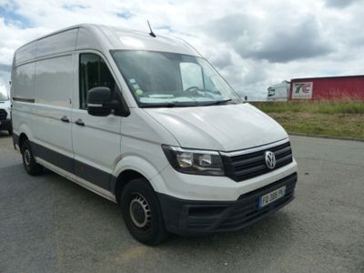 La camionnette blanche est garée sur le bord de la route, dans le parking.