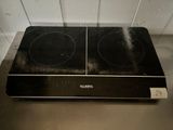 a black stove top with two burners on top of it