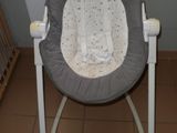 une photo d'une chaise berçante pour bébé dans une pièce