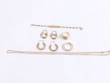 an assortment of gold and silver jewelry including a chain, ear rings, and a pair of earrings