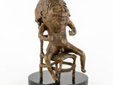 statue of a woman sitting on a chair with her hand on her chin