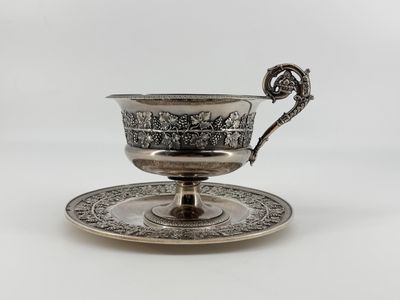 a silver cup and saucer on a saucer on a white background