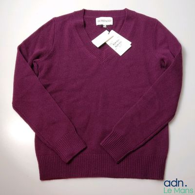 a close up of a purple sweater with a tag on it