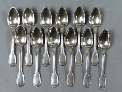 six cuillères en argent sont disposées en rangée sur une table