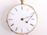 une horloge en or avec des chiffres romains sur le cadran