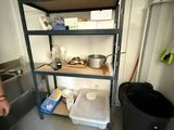 un homme debout dans une cuisine, à côté d'une poubelle