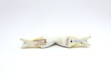two white ceramic fish figurines sitting on top of each other
