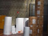many rolls of paper sitting on the floor in a warehouse