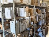boxes are stacked on a shelf in a warehouse with a clock