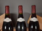 three bottles of wine sit in a wooden crate on a table