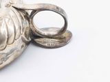 a silver ring sitting on top of a silver vase