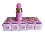 un flacon de parfum rose posé au sommet d'une pile de boîtes roses