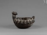 an image of a bronze bird shaped bowl on a gray surface