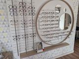 a display of glasses on a wall with a mirror