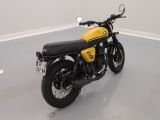 a yellow and black motorcycle parked in a white room