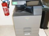 a multi - function printer sitting on the floor next to a fire extinguisor
