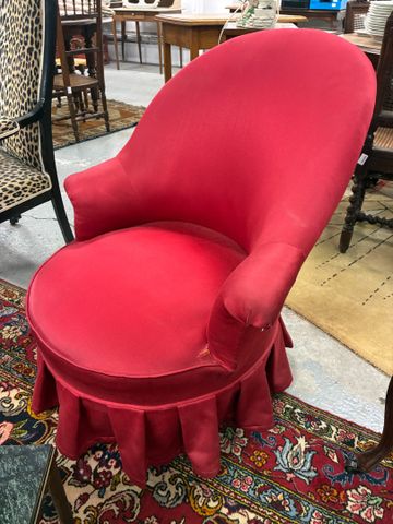 Fauteuil crapaud recouvert de tissu rouge (déchirures). 