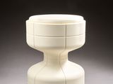 a white vase sitting on top of a white table