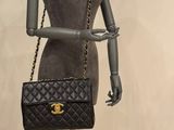 mannequin holding a chanel bag on display in front of a mannequin
