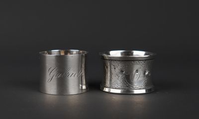a pair of silver cups with engraved names on them