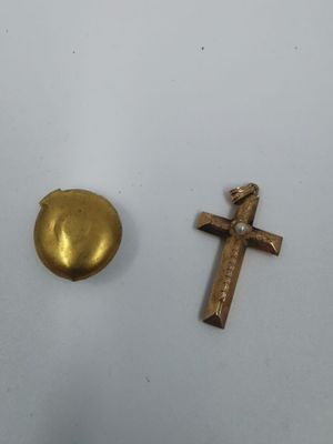 deux croix dorées et un œuf doré sur un fond blanc