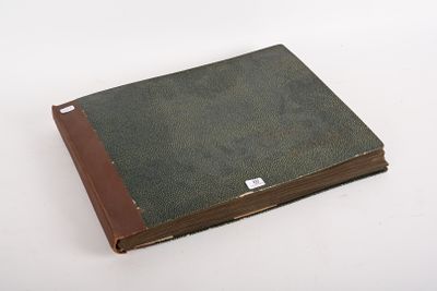 un vieux livre à la couverture marron posé sur une table blanche