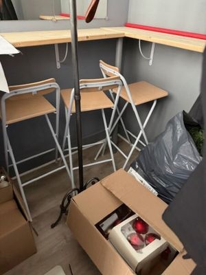 a room with a table, chairs, and a lamp in it