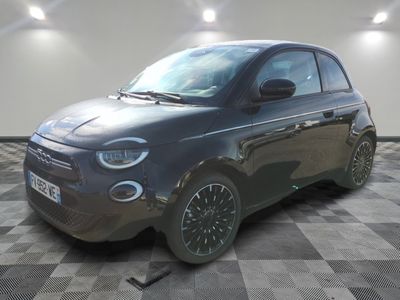 la photo d'une petite voiture noire garée sur un sol en damier